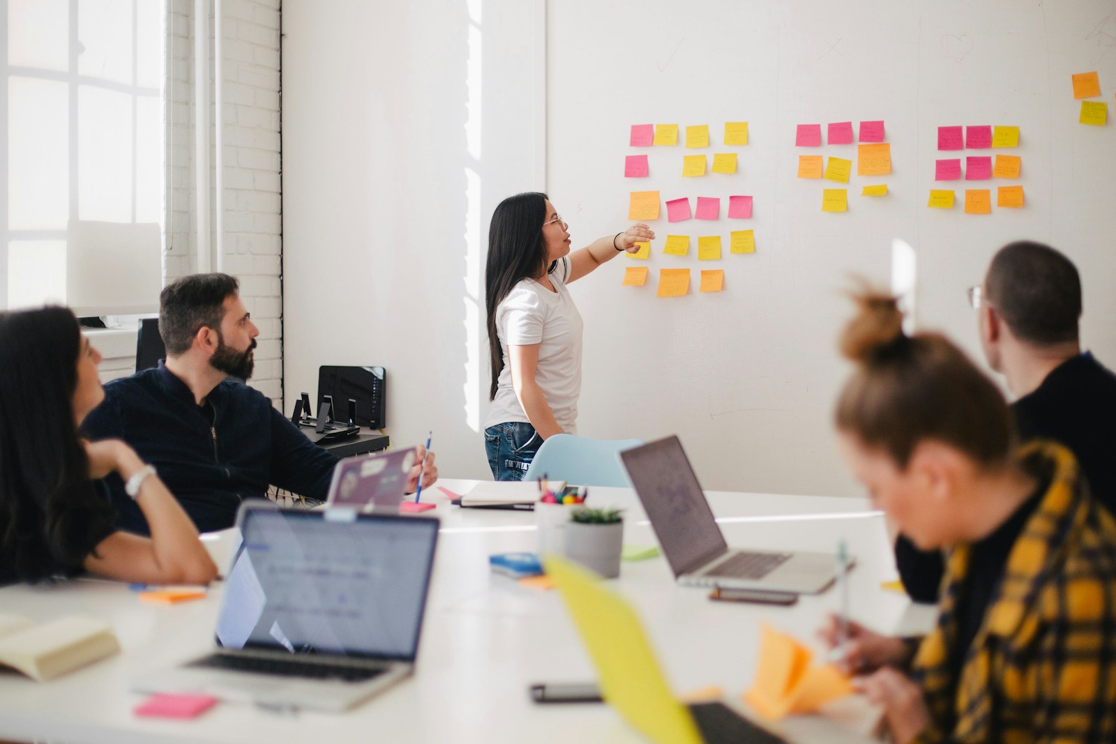 Strategists mapping audience segments on a studio wall with pinned notes and printed layouts